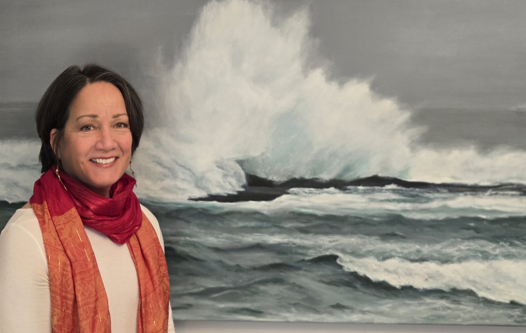 Artist Cecilia Humphrey stands to the left of her painting, displaying a crashing ocean wave.